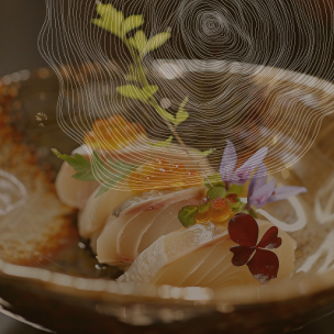 Un bol en céramique contient quatre morceaux de sashimi de poisson blanc, chacun garni d'une petite boule orange vif et décoré d'une feuille verte et d'une fleur comestible. En arrière-plan, un motif abstrait évoquant des cernes d'arbre et des feuilles apporte une touche artistique à l'ensemble.