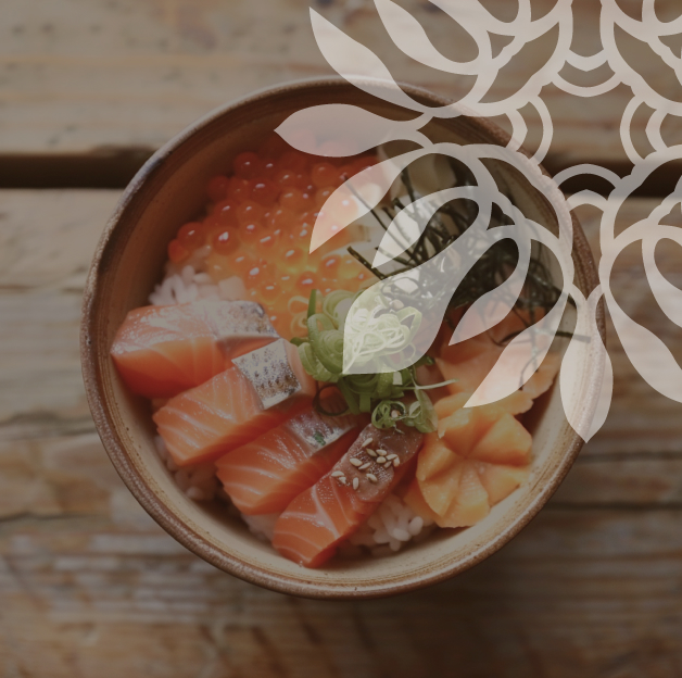 Un bol en céramique contient du riz, des tranches de saumon cru, des œufs de saumon, un morceau de poisson blanc et des lamelles d'oignon vert. Le bol repose sur une table en bois. Des graines de sésame sont saupoudrées sur le saumon. Un motif abstrait de feuilles et de fleurs est superposé à l'image.